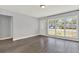 Bright living room with gray walls, new laminate flooring and a large window letting in natural light at 1908 E Mcberry St, Tampa, FL 33610