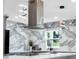 Close-up of a kitchen with unique backsplash, modern lighting, and stainless steel hood at 20 2Nd Se Ave, Lutz, FL 33549