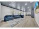 Open living room featuring a blue modular sofa, recessed lighting, and luxury vinyl flooring at 20 2Nd Se Ave, Lutz, FL 33549