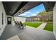 A patio area with seating overlooking the backyard, pool, and manicured lawn at 20 2Nd Se Ave, Lutz, FL 33549