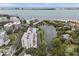 An aerial view of the condo building near a pond and waterfront shows its desirable location and community amenities at 220 Belleview Blvd # 701, Belleair, FL 33756