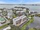 Elevated view of a residential area featuring multi-story buildings, a pond, and city skyline in the distance at 220 Belleview Blvd # 701, Belleair, FL 33756