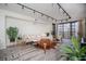 Bright living room featuring modern track lighting, stylish furniture, plants, and a balcony at 220 Belleview Blvd # 701, Belleair, FL 33756