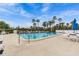 Community swimming pool surrounded by lounge chairs, palm trees, and a serene setting for relaxation and recreation at 220 Belleview Blvd # 701, Belleair, FL 33756