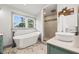 Bright bathroom features a soaking tub under a window, a tiled shower, and vessel sink at 292 Sunlit Cove Ne Dr, St Petersburg, FL 33702