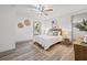 Well-lit bedroom featuring wood-look floors, a ceiling fan, and a cozy rug at 292 Sunlit Cove Ne Dr, St Petersburg, FL 33702