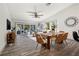 Open-concept dining room with a wooden table, stylish chairs, and sliding glass doors to the outdoor area at 292 Sunlit Cove Ne Dr, St Petersburg, FL 33702