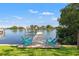 Beautiful waterfront view of the backyard dock featuring two aqua chairs perfect for relaxing by the water at 292 Sunlit Cove Ne Dr, St Petersburg, FL 33702