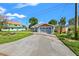 Blue single-story house featuring a well-manicured lawn and a spacious driveway at 292 Sunlit Cove Ne Dr, St Petersburg, FL 33702