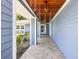 Inviting covered front porch features stone flooring, wooden ceiling, and light blue siding with ample space at 292 Sunlit Cove Ne Dr, St Petersburg, FL 33702