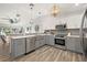 Spacious open concept kitchen features stainless appliances, gray cabinets, and wood-look tile flooring at 292 Sunlit Cove Ne Dr, St Petersburg, FL 33702