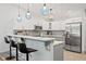 Stylish kitchen featuring bar seating, stainless steel appliances, and white upper cabinets with gray lowers at 292 Sunlit Cove Ne Dr, St Petersburg, FL 33702