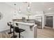 Modern kitchen boasts stainless steel appliances, stylish pendant lighting, bar seating, and white cabinets at 292 Sunlit Cove Ne Dr, St Petersburg, FL 33702