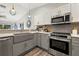 Kitchen features stainless steel appliances, modern two-tone cabinets and stone countertops at 292 Sunlit Cove Ne Dr, St Petersburg, FL 33702