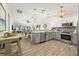 Bright kitchen with gray cabinets, stainless steel appliances, wood-look floors, and views of the patio at 292 Sunlit Cove Ne Dr, St Petersburg, FL 33702