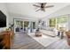 Comfortable living room features a ceiling fan, tile floors, and sliding glass doors to the patio at 292 Sunlit Cove Ne Dr, St Petersburg, FL 33702