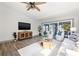 Comfortable living room features a ceiling fan, tile floors, and sliding glass doors to the water at 292 Sunlit Cove Ne Dr, St Petersburg, FL 33702