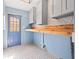Mud room features gray upper cabinets, blue walls, a wood shelf and decorative tile flooring at 292 Sunlit Cove Ne Dr, St Petersburg, FL 33702