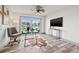 Bright office space with a glass desk, comfortable chair, and a view of the waterfront through sliding glass doors at 292 Sunlit Cove Ne Dr, St Petersburg, FL 33702