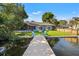 Waterfront home featuring a private dock with chairs, lush lawn, and serene views at 292 Sunlit Cove Ne Dr, St Petersburg, FL 33702