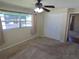 Comfortable carpeted bedroom featuring a ceiling fan, window, closet, and neutral decor at 3122 Egret Ter, Safety Harbor, FL 34695