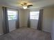 Inviting carpeted bedroom with ceiling fan, two windows, and neutral decor offers a comfortable retreat at 3122 Egret Ter, Safety Harbor, FL 34695