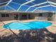 The kidney-shaped pool features a brick patio and a covered ceiling at 3122 Egret Ter, Safety Harbor, FL 34695