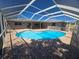 Aerial view of the kidney-shaped pool and brick patio with covered ceiling at 3122 Egret Ter, Safety Harbor, FL 34695