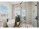 Bright bathroom with a free standing soaking tub, shower with glass enclosure, and patterned accent wall at 315 64Th St, Holmes Beach, FL 34217