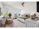 Bright bedroom features a ceiling fan, an accent wall, and a cozy sitting area by the window at 315 64Th St, Holmes Beach, FL 34217