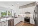Modern kitchen with an island including bar seating and stainless steel appliances with views of the patio at 315 64Th St, Holmes Beach, FL 34217