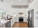 Well-lit kitchen with stainless steel appliances, stone countertops, and a classic subway tile backsplash at 315 64Th St, Holmes Beach, FL 34217