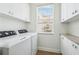 Functional laundry room with modern appliances, ample cabinet space, and a window providing natural light at 315 64Th St, Holmes Beach, FL 34217