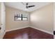 Bedroom with dark hardwood floors, ceiling fan, and window with blinds at 3256 Roxborough Ave, Clearwater, FL 33762