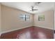 Bedroom with dark hardwood floors, ceiling fan, and two windows with blinds at 3256 Roxborough Ave, Clearwater, FL 33762