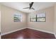 Bedroom with dark hardwood floors, ceiling fan, and two windows with blinds at 3256 Roxborough Ave, Clearwater, FL 33762