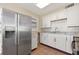 Traditional kitchen featuring tile backsplash, white cabinets, and stainless steel refrigerator at 3256 Roxborough Ave, Clearwater, FL 33762
