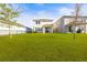 Expansive backyard with lush green grass, privacy fence, and covered patio at 34024 White Fountain Ct, Wesley Chapel, FL 33545