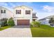 Charming two-story home showcasing a manicured lawn, paver driveway, and a neutral color scheme at 34024 White Fountain Ct, Wesley Chapel, FL 33545