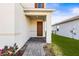 Inviting front porch with a brown door, stone pavers, and lush landscaping at 34024 White Fountain Ct, Wesley Chapel, FL 33545