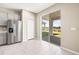 Kitchen with stainless appliances, pantry, and sliding glass door to backyard providing a seamless indoor-outdoor experience at 34024 White Fountain Ct, Wesley Chapel, FL 33545