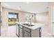 Kitchen island with stainless steel sink and dishwasher complemented by natural light and an open view to backyard at 34024 White Fountain Ct, Wesley Chapel, FL 33545