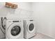 Laundry room with Whirlpool washer and dryer on a tile floor with overhead shelving at 34024 White Fountain Ct, Wesley Chapel, FL 33545