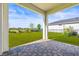 Covered patio with paver flooring and views of the backyard and green space at 34024 White Fountain Ct, Wesley Chapel, FL 33545