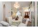 Elegant dining room featuring a glass-top table, chandelier, and views into the living room and front entrance at 3627 Cypress Meadows Rd, Tampa, FL 33624