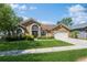 Charming single-story home with well-manicured lawn, mature trees, and a two-car garage at 3627 Cypress Meadows Rd, Tampa, FL 33624