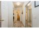 Bright hallway with mirrored closet doors, leading to a bathroom with a glass shower door at 3627 Cypress Meadows Rd, Tampa, FL 33624