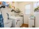 Efficient laundry room with modern washer, dryer, storage shelves, utility sink, and bright natural light at 3627 Cypress Meadows Rd, Tampa, FL 33624