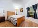 Bright bedroom features wood-look floors, a wooden bed frame, and natural light from a window at 39650 Us Highway 19 N # 411, Tarpon Springs, FL 34689