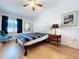 Cozy bedroom with a ceiling fan, accent chair, and a window with dark curtains at 39650 Us Highway 19 N # 411, Tarpon Springs, FL 34689